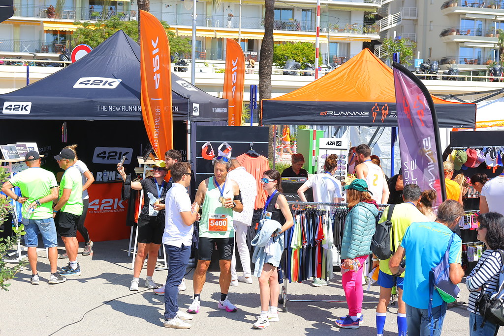 des stands des partenaires de l'évènement sous le soleil avec des coureurs et des familles