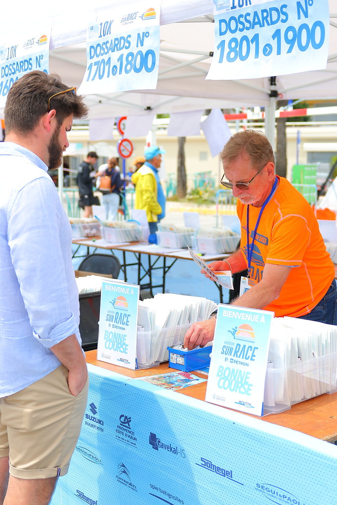 bénévole menton sun race sous une tente renseignant un futur coureur