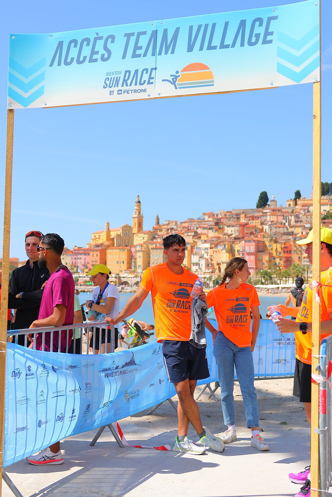 bénévole de la Team village menton sun race 2026, mer et ville de menton en arrière plan