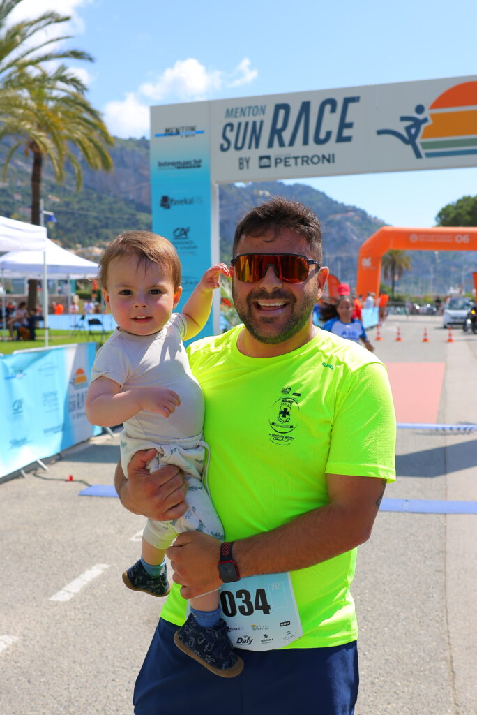Coureur course Ronde des plages 5k de menton sun race tenant son enfant
