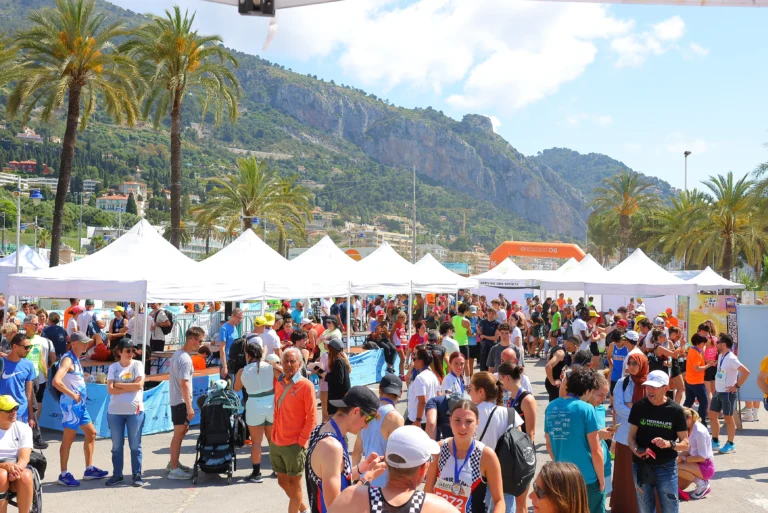 Photo de l'ambiance du site de départ, avec beaucoup de tentes, du soleil, des coureurs et des familles